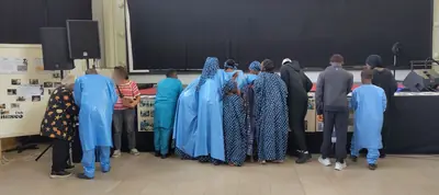 Un groupe de personnes en tenues bleues debout dans la salle, face à la scène.