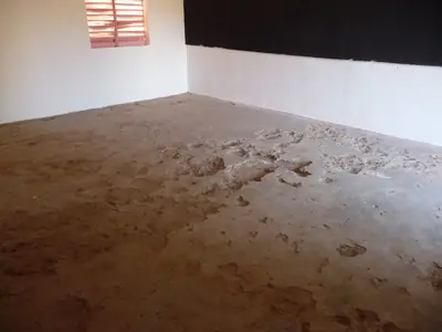 Une classe au sol abîmé, avant les travaux.